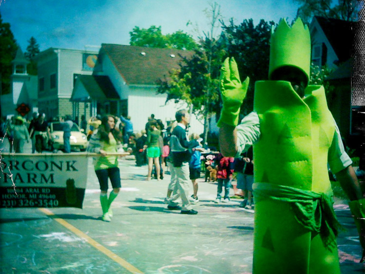 person waving in asparagus costume