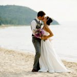just married couple kissing on Lake Michigan beach up north