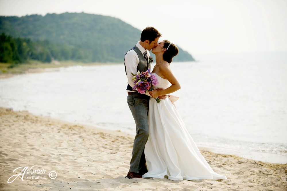 just married couple kissing on Lake Michigan beach up north