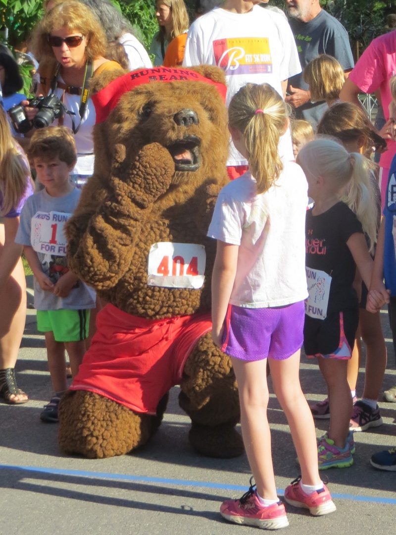 kids high five person in bear costume