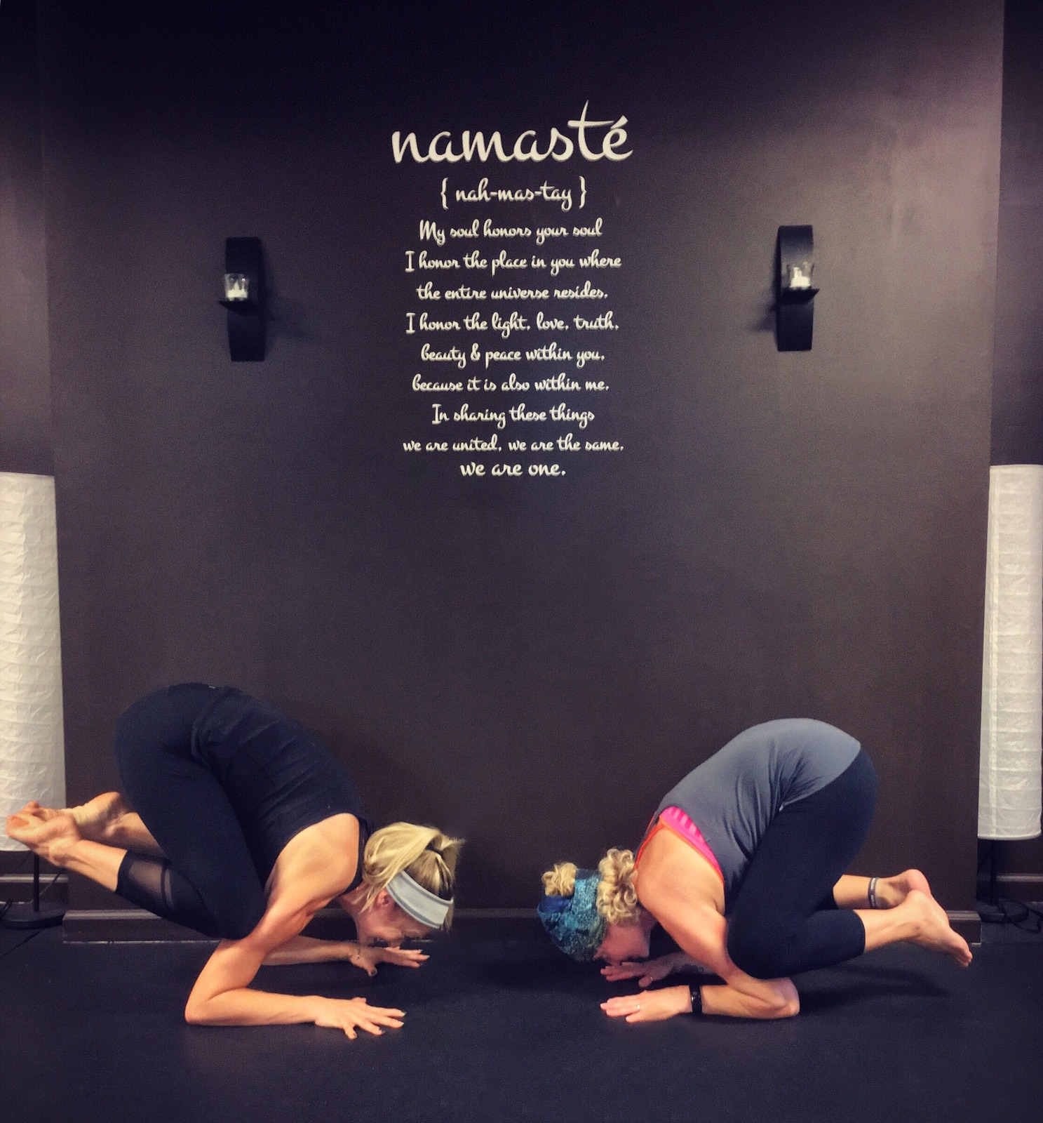namaste quote on wall women doing yoga pose