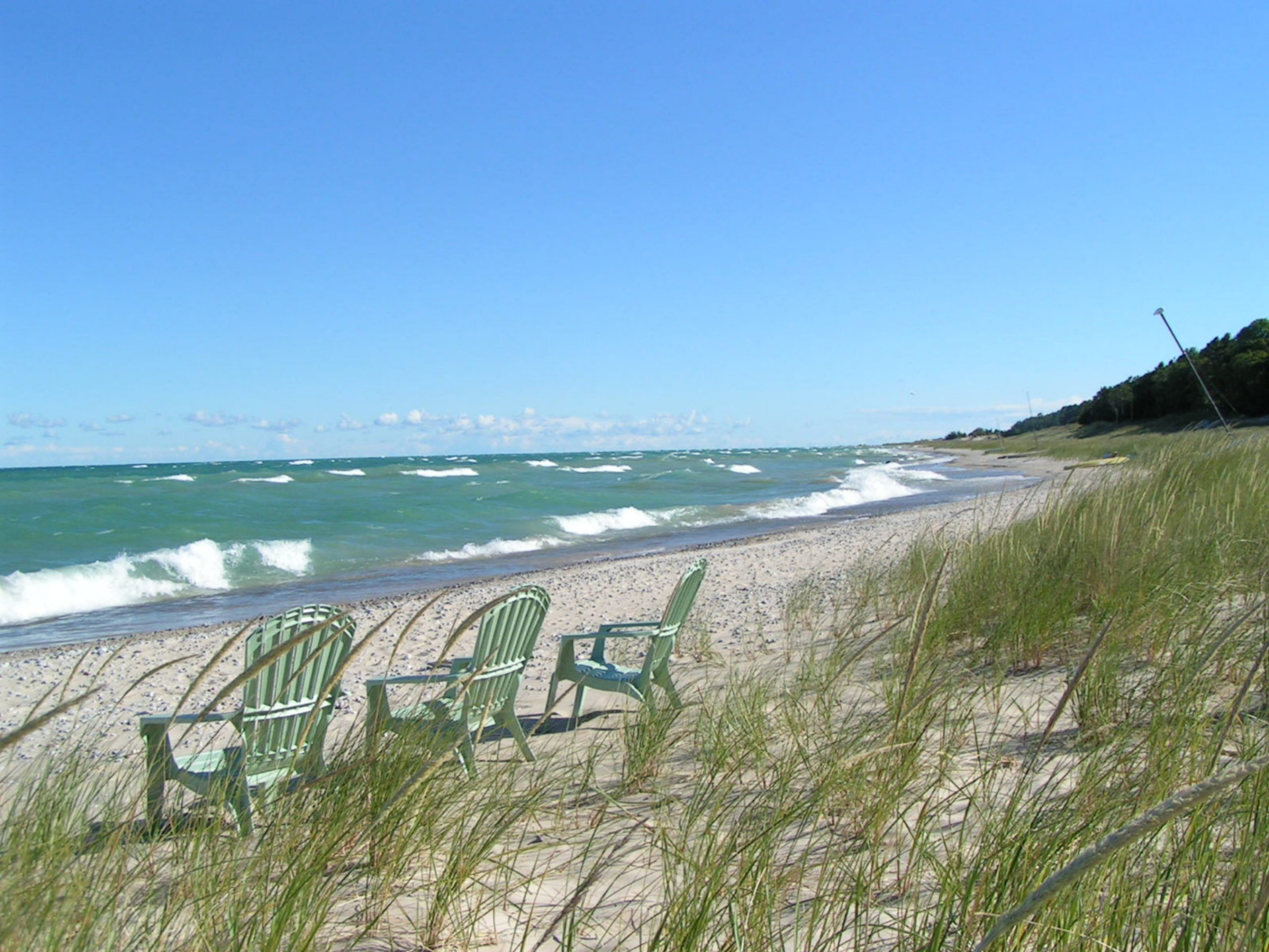 Adirondack chairs on beach with dune grass