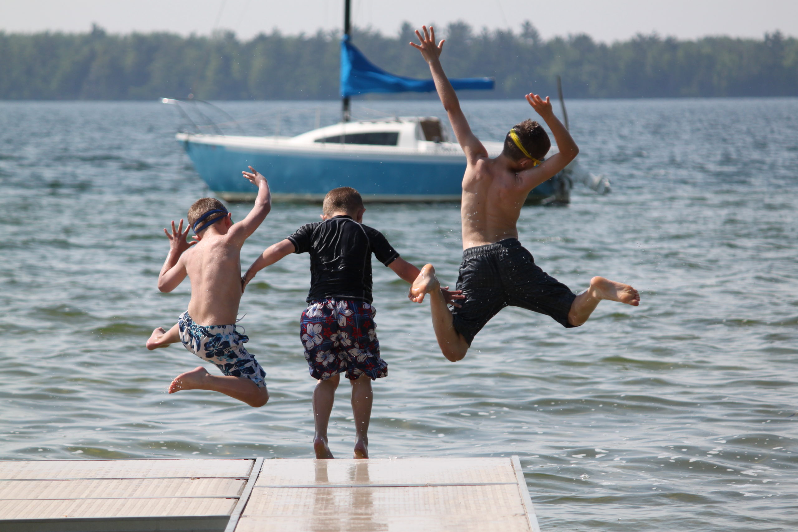 kids leaping off dock into water