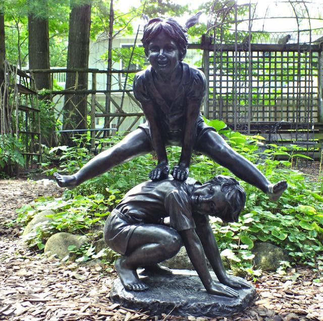 kids leaping statue in garden