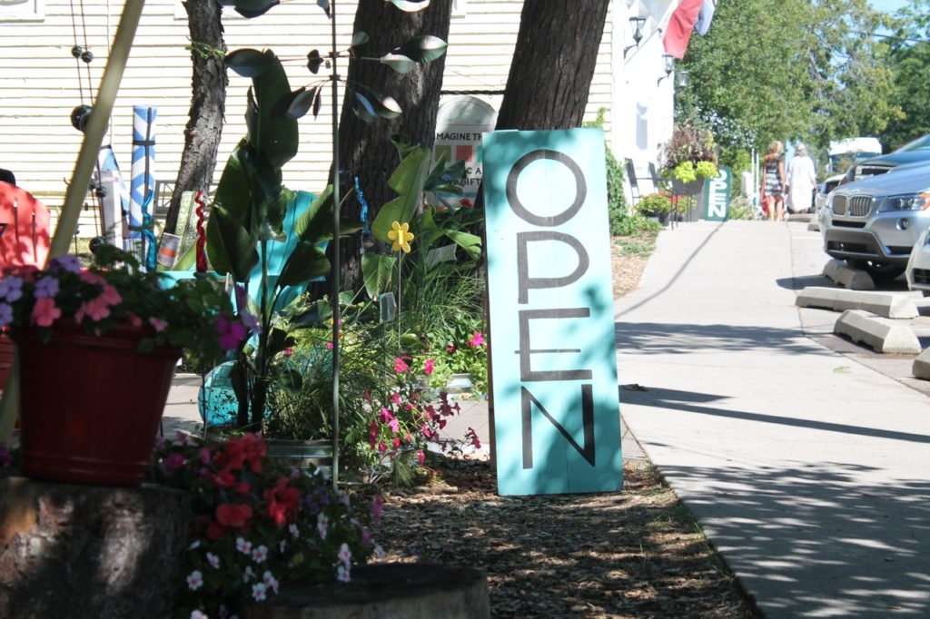 blue sandwich open sign by sidewalk