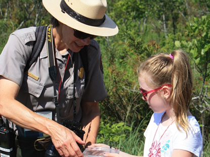 ranger teaching child out in nature