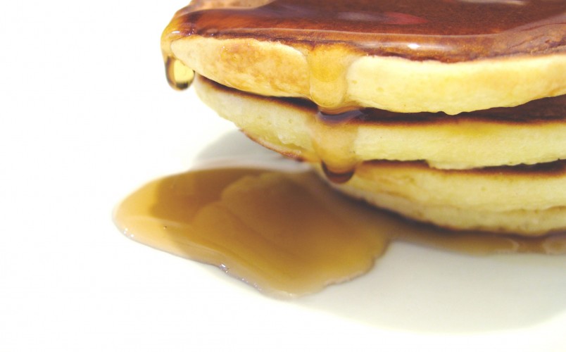 stack of pancakes dripping with syrup