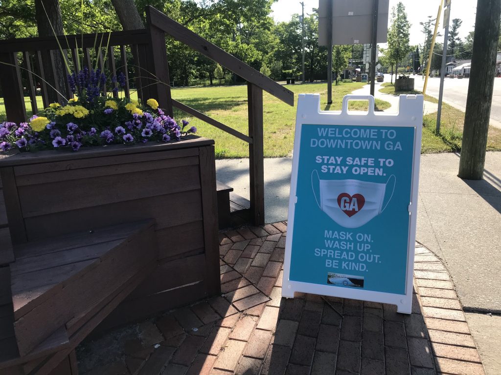 stay safe to stay open sandwich board sign on sidewalk in Glen Arbor