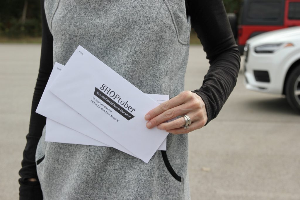 woman holding SHOPtober event envelopes