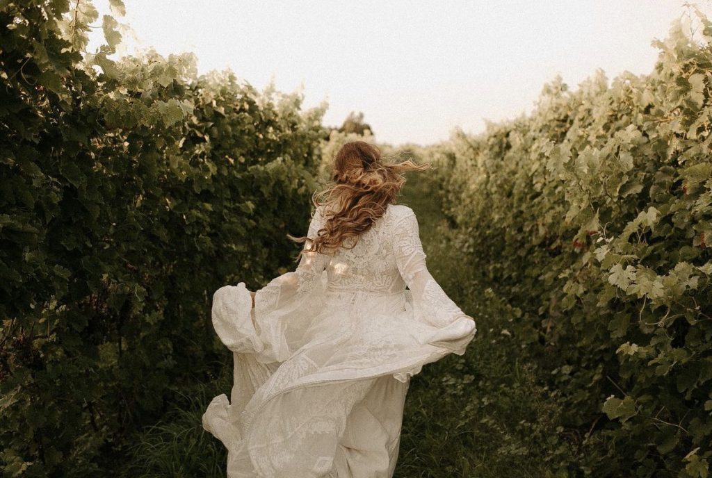 bride skipping through vineyard